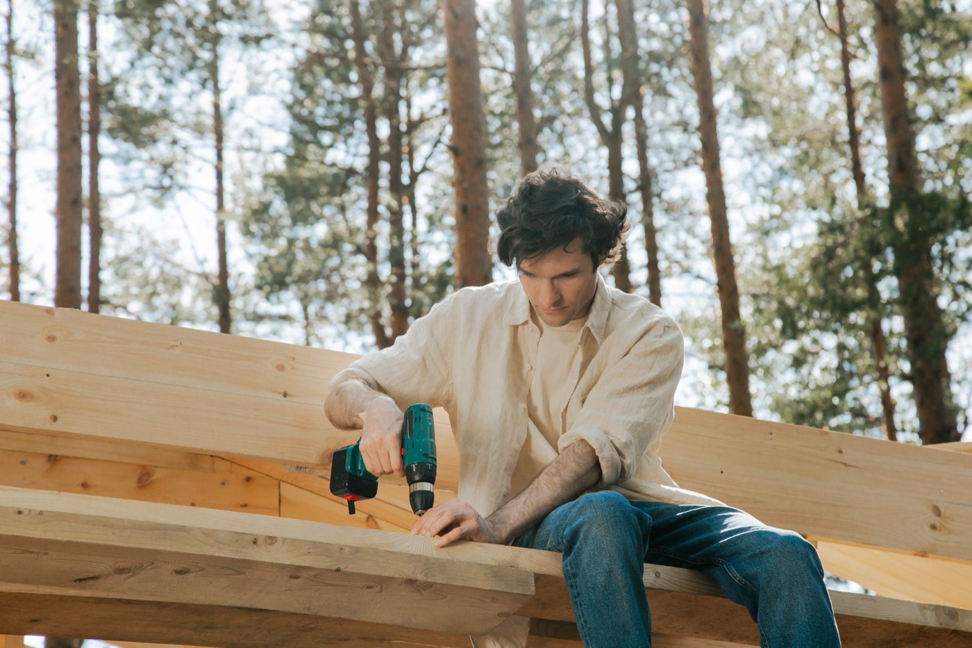 Carpenter drilling into new lumber outdoors