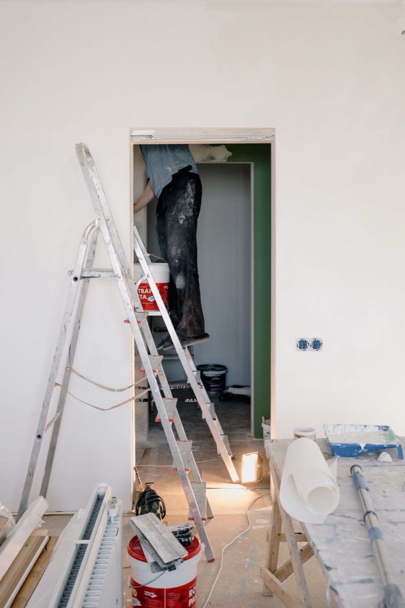Empty room mid renovation with a ladder and paint